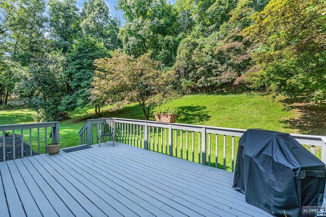 wooden terrace featuring a yard and area for grilling