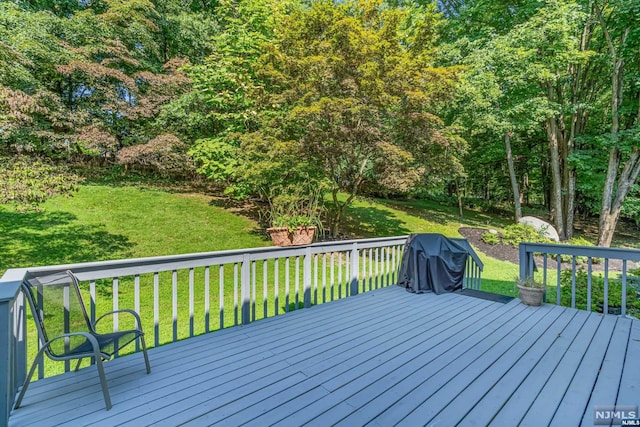 wooden terrace featuring a yard