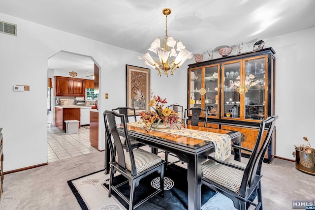 dining area with a notable chandelier and light colored carpet