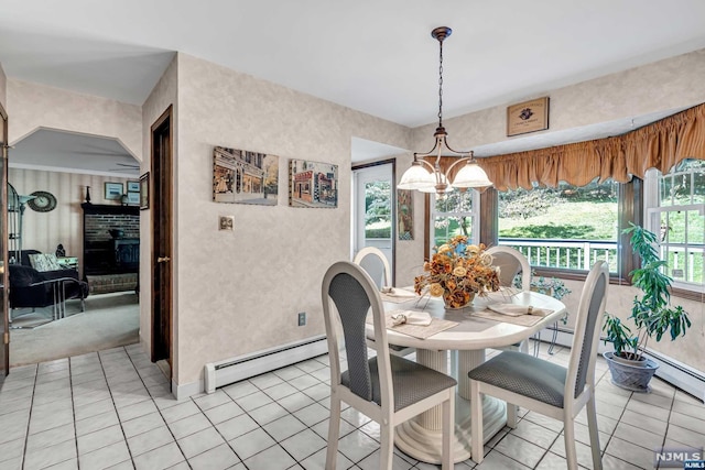 dining area featuring a notable chandelier, light tile patterned floors, baseboard heating, and a brick fireplace