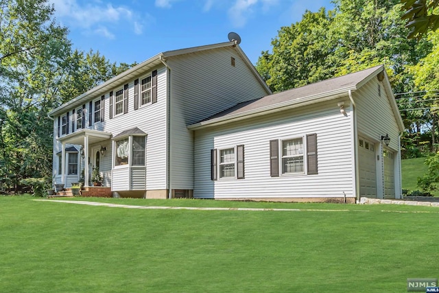 colonial inspired home featuring a garage and a front lawn