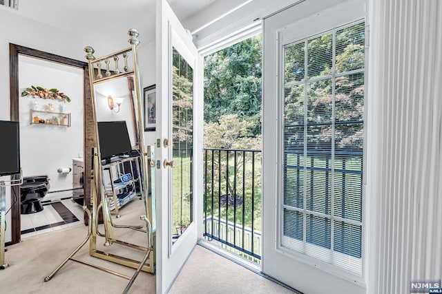 doorway featuring baseboard heating, plenty of natural light, and carpet floors