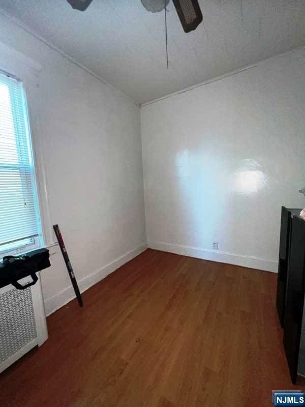 spare room with dark wood-type flooring and ceiling fan