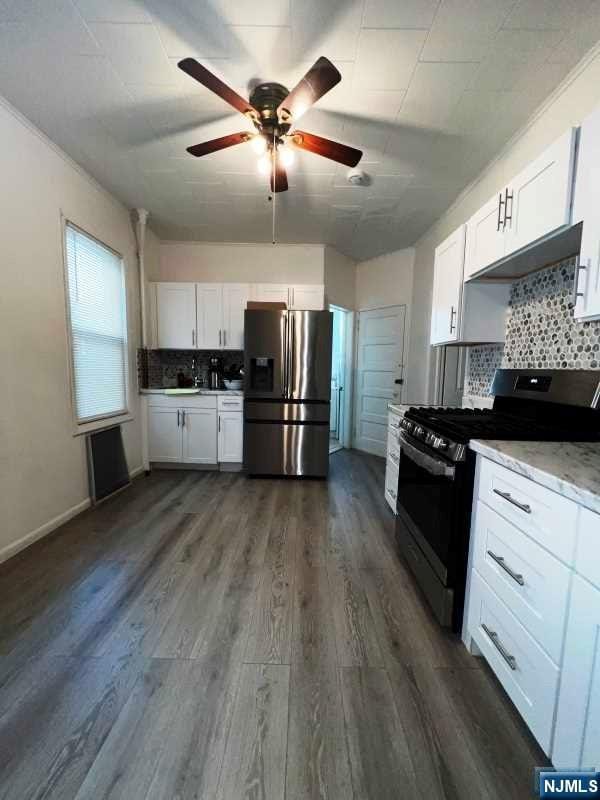 kitchen featuring black range with gas cooktop, tasteful backsplash, stainless steel refrigerator with ice dispenser, white cabinets, and dark hardwood / wood-style flooring