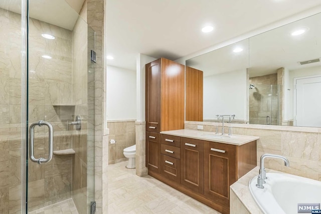 full bathroom featuring separate shower and tub, vanity, tile walls, and toilet