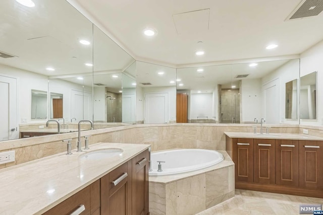 bathroom featuring vanity and independent shower and bath