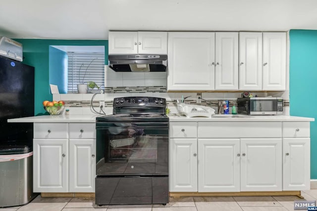 kitchen featuring black electric range oven, light tile patterned floors, white cabinetry, and tasteful backsplash