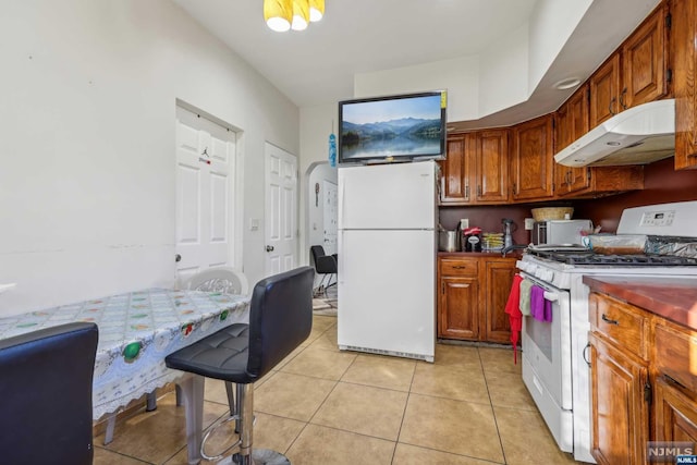 kitchen with light tile patterned flooring and white appliances