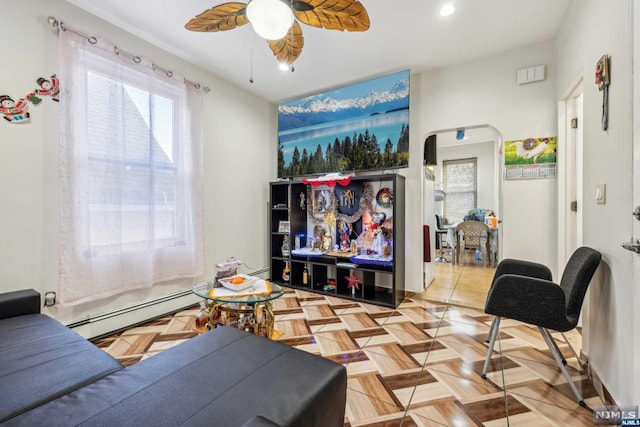 living room featuring ceiling fan, light parquet floors, and a baseboard radiator