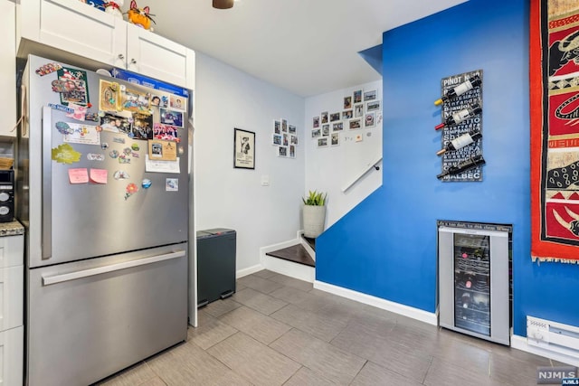 kitchen featuring white cabinets, stainless steel fridge, and beverage cooler