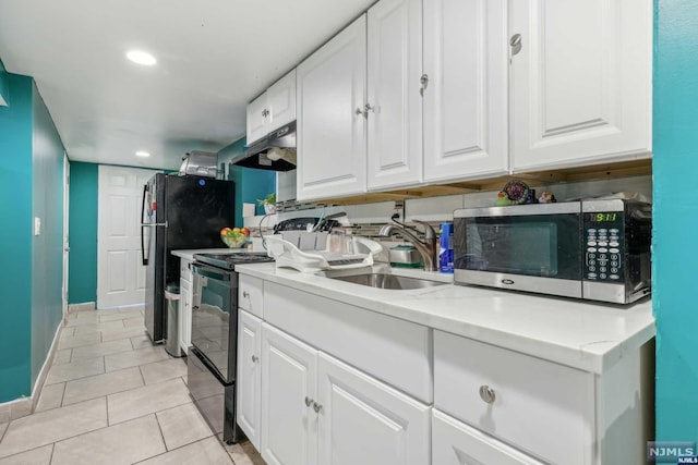 kitchen with sink, light tile patterned floors, ventilation hood, white cabinets, and black appliances