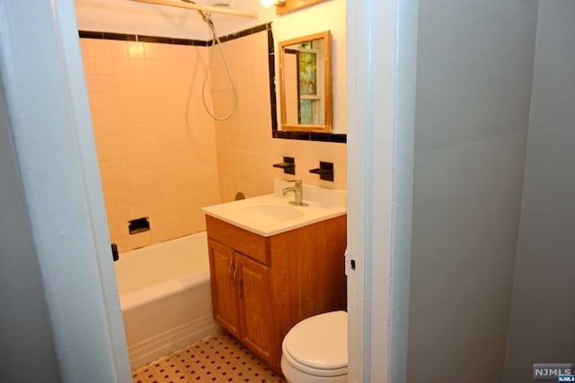 full bathroom with vanity, tiled shower / bath, and toilet