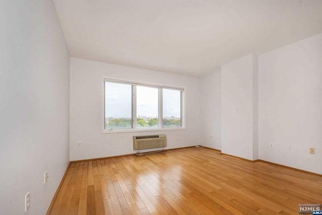 spare room featuring light hardwood / wood-style floors and a wall mounted AC