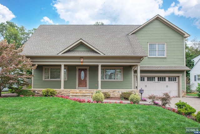 view of front of house with a porch, a garage, and a front lawn