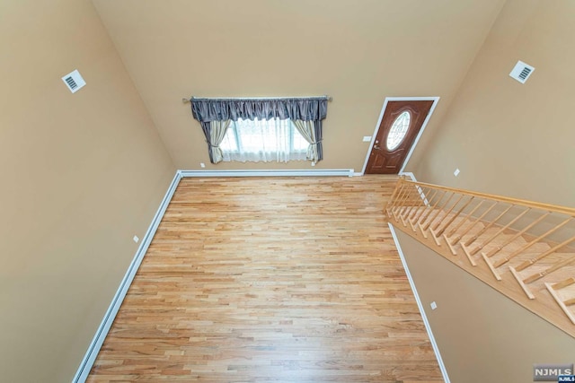 foyer entrance featuring a high ceiling and hardwood / wood-style flooring