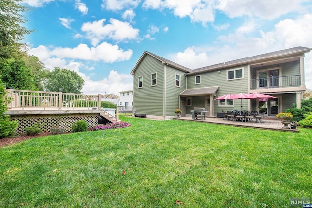 back of house with a yard, a patio, and a wooden deck