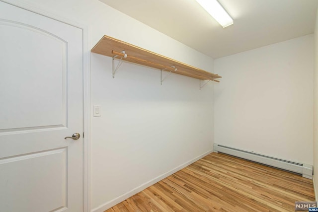 spacious closet with light hardwood / wood-style floors and baseboard heating