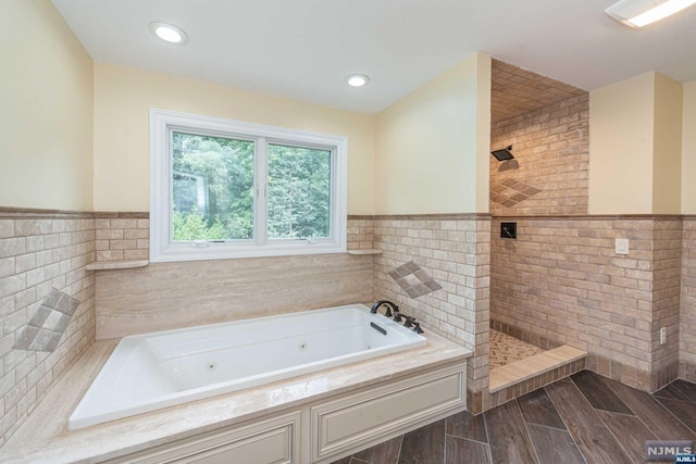 bathroom with independent shower and bath and tile walls