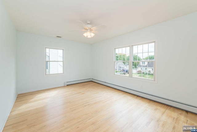 spare room with plenty of natural light, ceiling fan, and light wood-type flooring