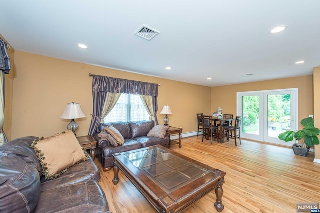 living room featuring light wood-type flooring and a baseboard heating unit