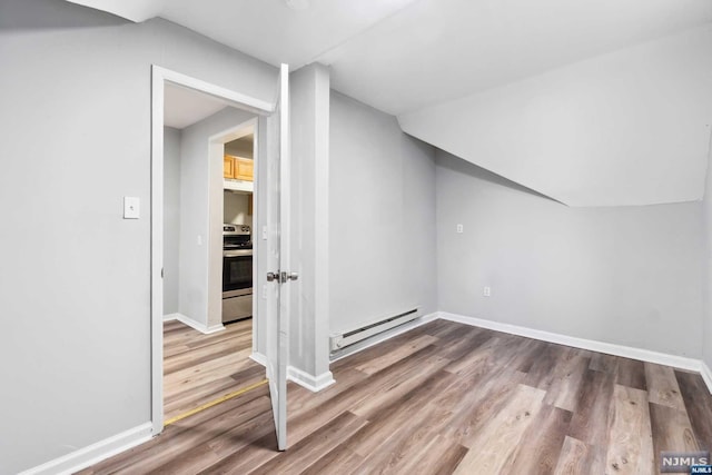 additional living space featuring hardwood / wood-style flooring and baseboard heating