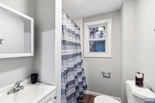 bathroom with a shower with shower curtain, vanity, hardwood / wood-style flooring, and toilet