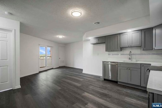 kitchen featuring dark hardwood / wood-style flooring, stainless steel dishwasher, gray cabinetry, and sink