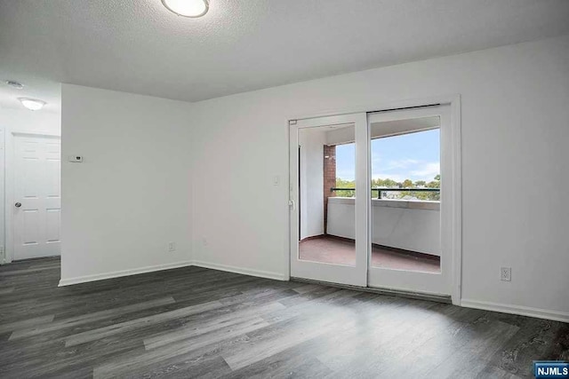 spare room with dark hardwood / wood-style flooring and a textured ceiling