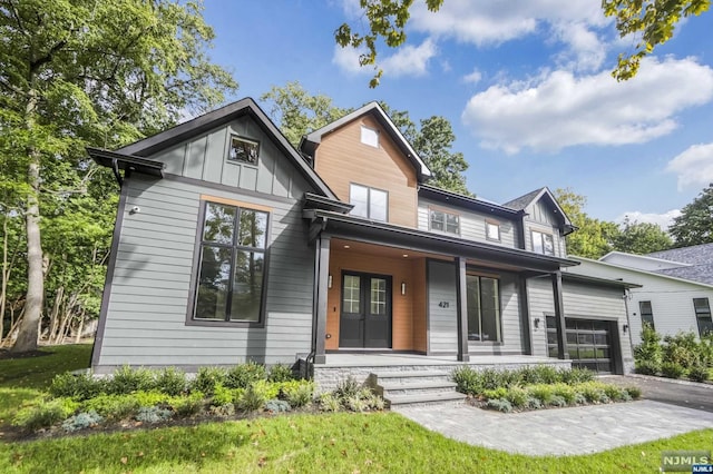 view of front of property with french doors, a porch, and a garage