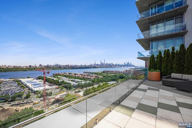 balcony featuring an outdoor living space and a water view