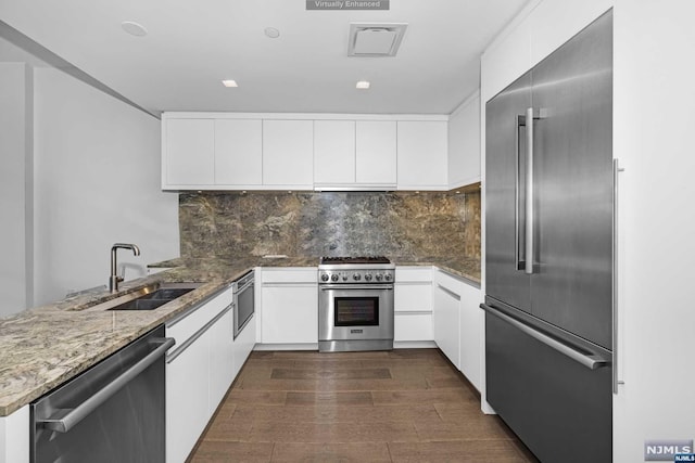 kitchen featuring sink, white cabinets, dark wood-type flooring, and high end appliances