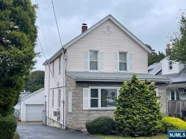 view of front facade with a garage and an outbuilding