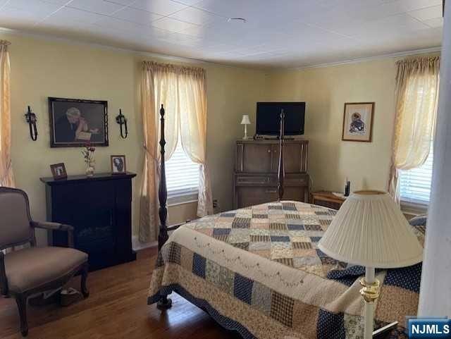 bedroom with ornamental molding and hardwood / wood-style flooring