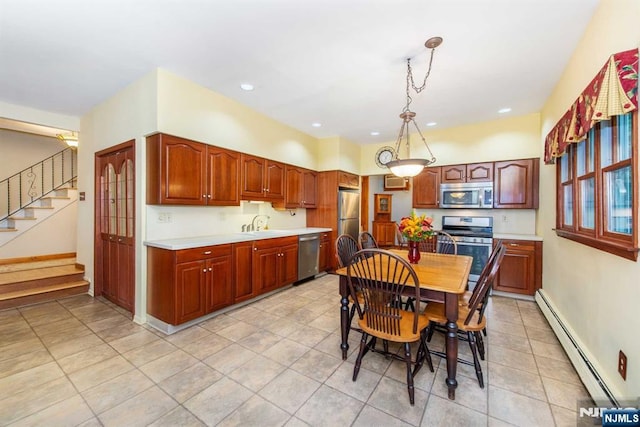 kitchen featuring a baseboard radiator, light countertops, hanging light fixtures, appliances with stainless steel finishes, and a sink