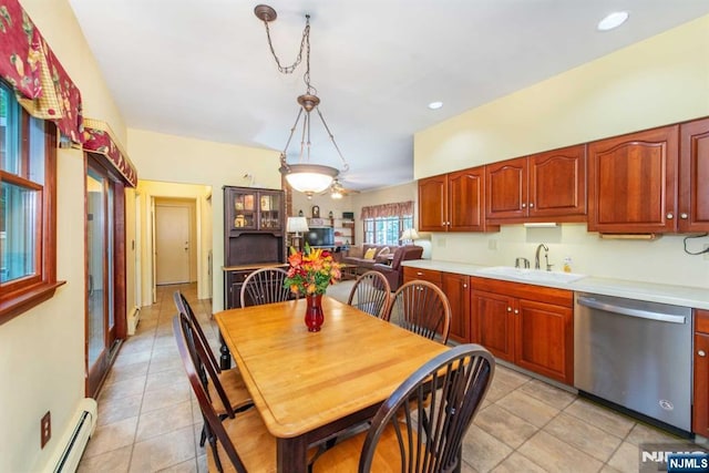 kitchen with a sink, light countertops, baseboard heating, dishwasher, and decorative light fixtures