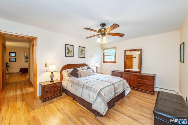 bedroom featuring ceiling fan, a baseboard radiator, and light wood-style flooring