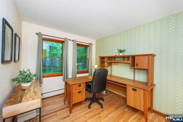 office space with wallpapered walls, a baseboard radiator, baseboards, and light wood-style floors