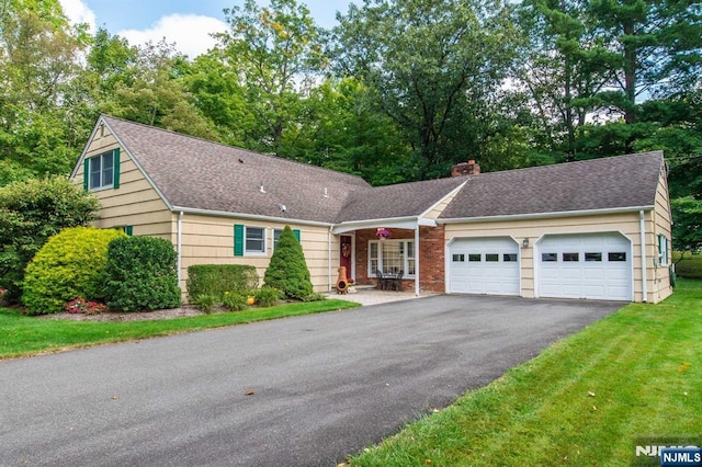 view of front facade with a garage, aphalt driveway, a chimney, and a shingled roof