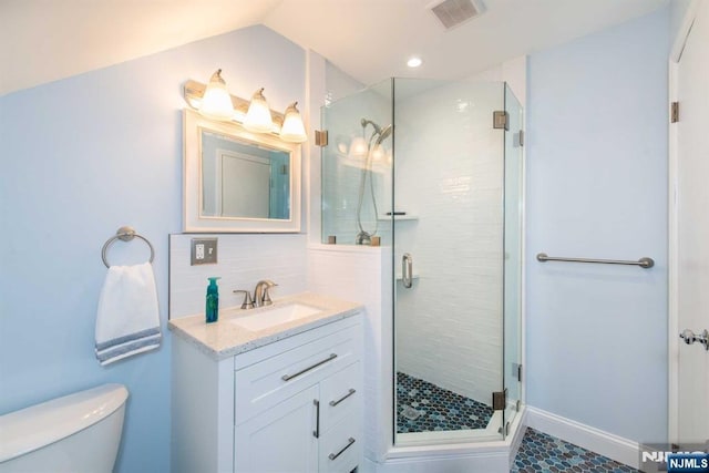 bathroom with toilet, vanity, visible vents, a shower stall, and decorative backsplash