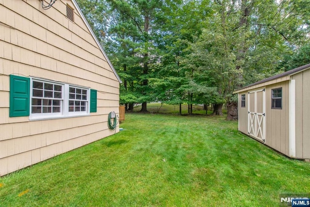 view of yard featuring a shed, an outdoor structure, and fence