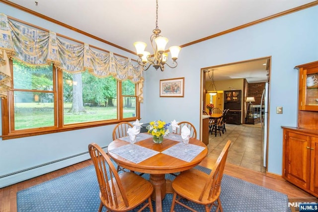 dining area with a baseboard heating unit, a notable chandelier, light wood-style flooring, and crown molding