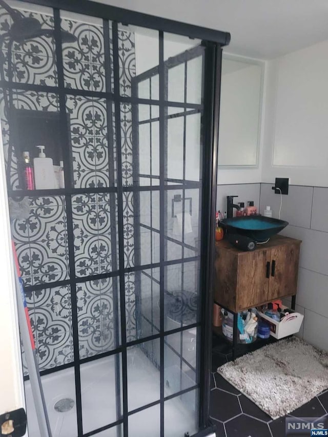 bathroom featuring sink and tile walls