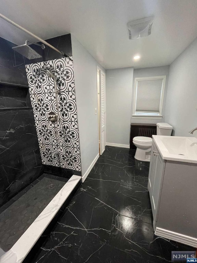 bathroom featuring a shower, vanity, and toilet