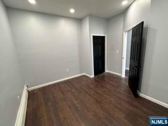 unfurnished room featuring dark wood-type flooring