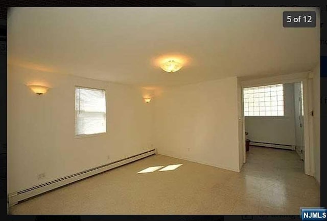 spare room with a wealth of natural light and a baseboard radiator