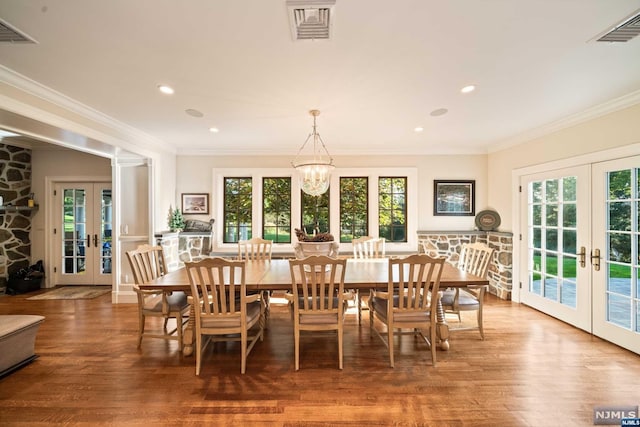 dining area with hardwood / wood-style floors, plenty of natural light, and french doors