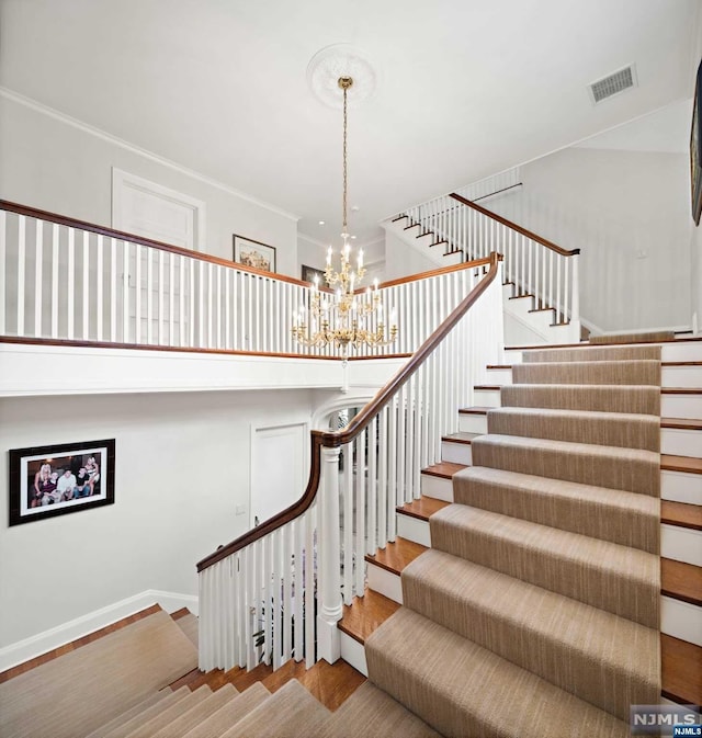 stairs with hardwood / wood-style flooring and an inviting chandelier