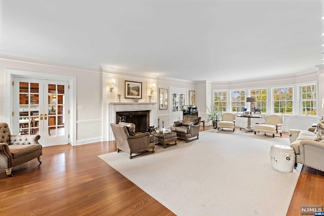 living room featuring hardwood / wood-style floors, crown molding, and french doors