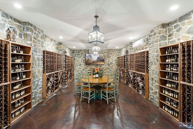 wine cellar with dark wood-type flooring and a wall mounted air conditioner