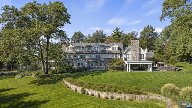 back of house featuring a patio, a balcony, and a lawn